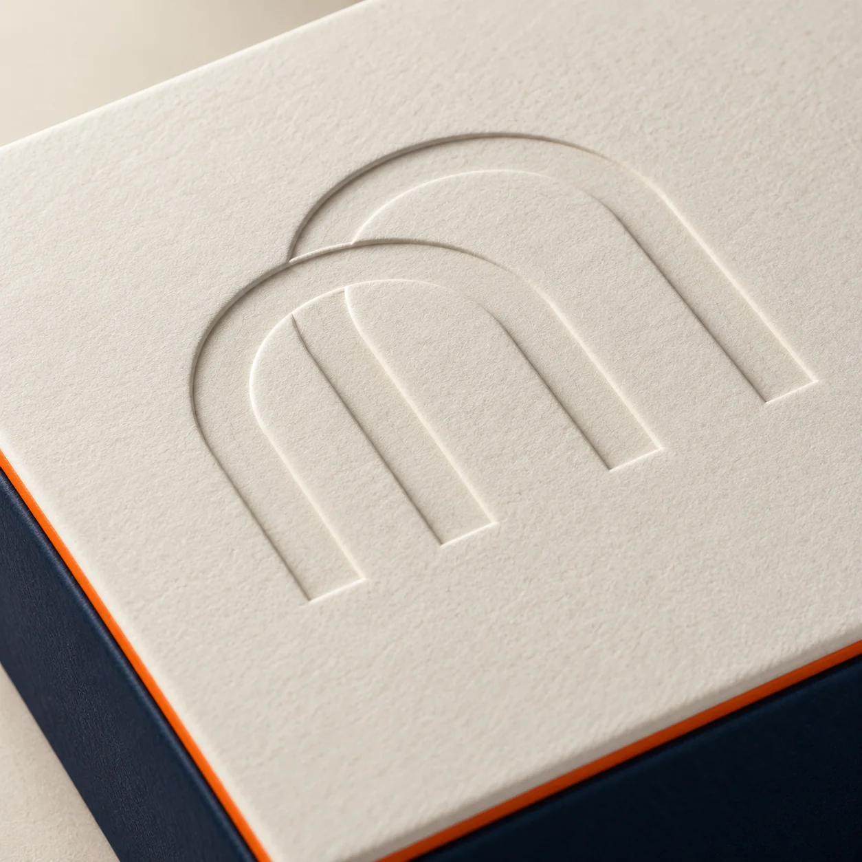 Recessed blind-debossed arch motif pressed into white paperboard