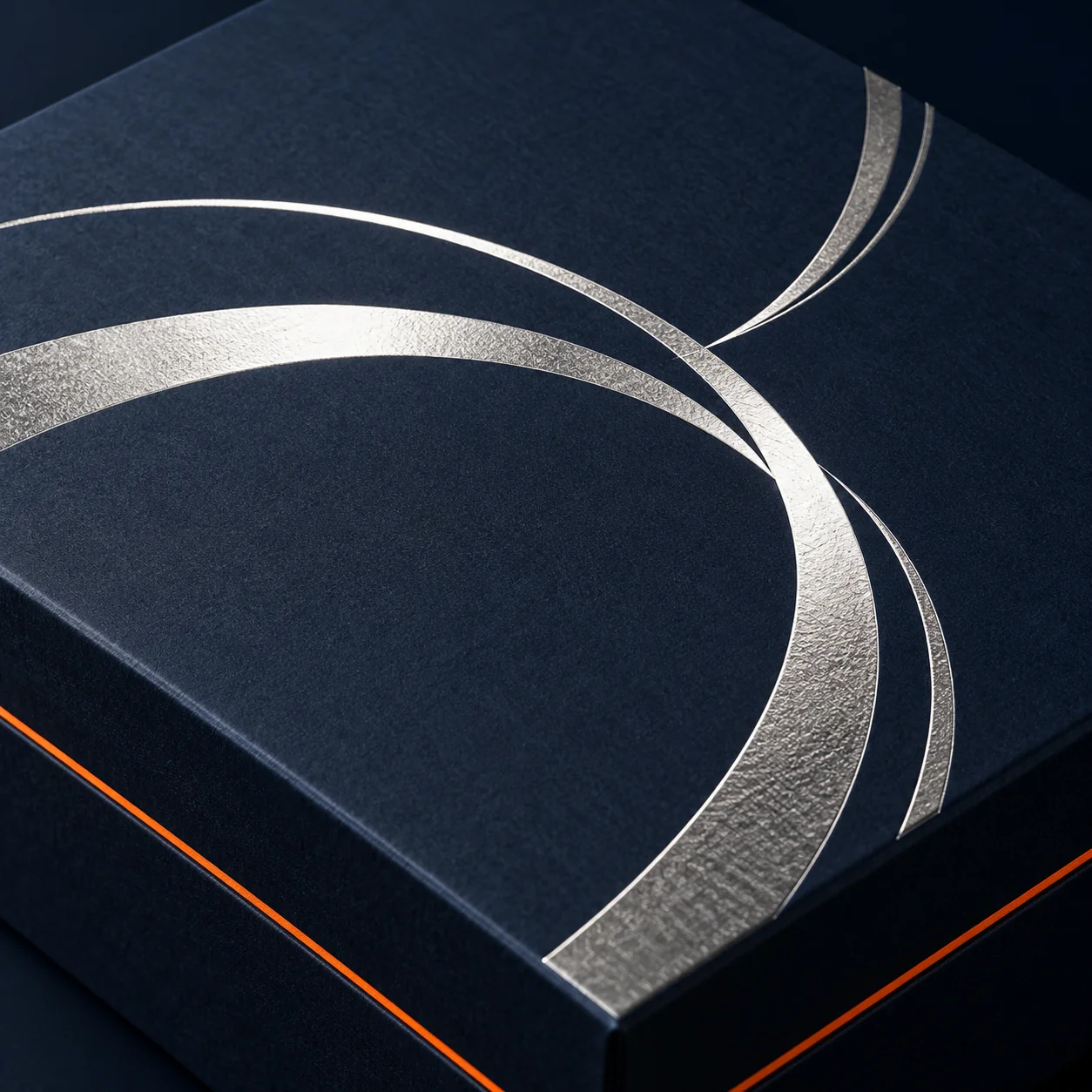 Reflective silver foil curves on matte navy packaging board